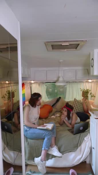Two Beautiful Hippie Girls Bed Trailer Laptop Book Camera Slowly — стоковое видео