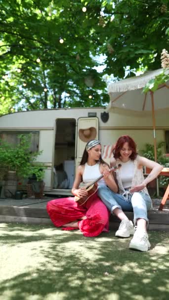 Two Beautiful Hippie Girls Singing Song Sitting Terrace Trailer Guitar — стоковое видео