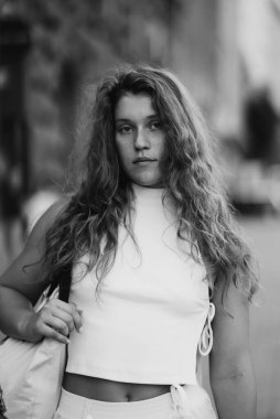 A stylish young girl with curly hair in a black and white portrait. High quality photo