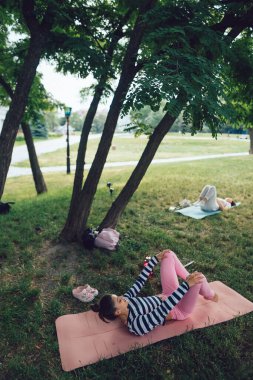 Parkta yoga seansı sırasında bacak esnetiyorum. Yüksek kalite fotoğraf