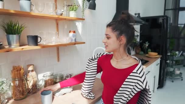 Das Mädchen Erledigt Küchenarbeiten Und Plaudert Während Einen Laptop Bei — Stockvideo