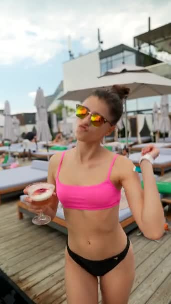 彼女の手にカクテルとビーチで踊るビキニの若い美しいセクシーな女の子 高品質4K映像 — ストック動画