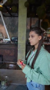 Genç bir kız dudaklarına dudak kremi sürüyor. Yüksek kalite 4k görüntü