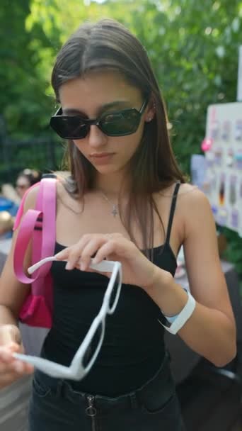 Urocza Młoda Dziewczyna Testuje Letnie Odcienie Rynku Wysokiej Jakości Materiał — Wideo stockowe
