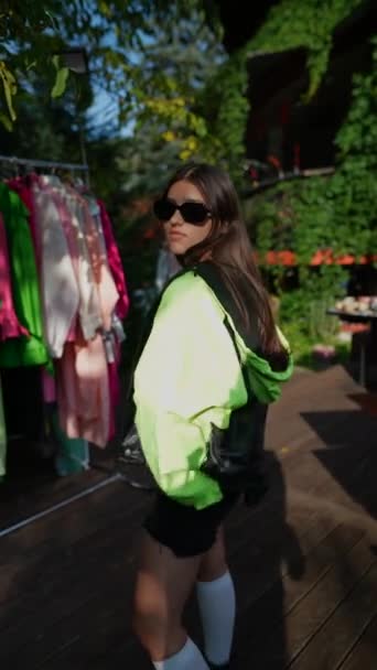 在夏季公园展示会的摊位上 一个年轻姑娘选择了醒目的服装 优质Fullhd影片 — 图库视频影像