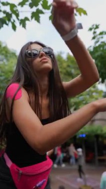 Kamera, yaz parkındaki festivalde genç ve güzel bir kadının enerjik dansını takip ediyor. Yüksek kaliteli FullHD görüntüler
