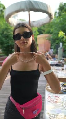 Markette küpelerle deneyler yapan genç bir kızın çekici yüzü. Yüksek kaliteli FullHD görüntüler