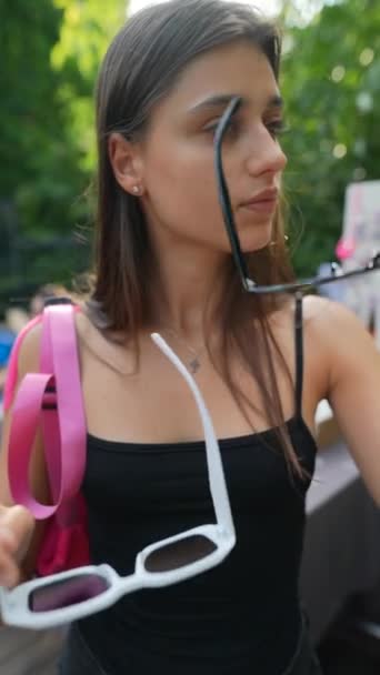 Piękna Młoda Kobieta Przymierzająca Letnie Okulary Jarmarku Wysokiej Jakości Materiał — Wideo stockowe