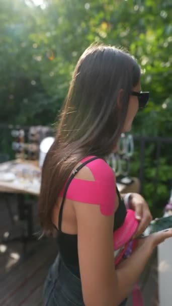 这个手上拿着玫瑰色腕带的聪明而又现代的女孩正在市场上挑选一件珠宝 优质Fullhd影片 — 图库视频影像