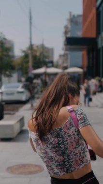 Bir tarz duygusuyla, genç kız işe geç kaldığını fark ederek şehir sokaklarında koşuşturuyor. Yüksek kalite 4k görüntü