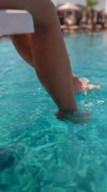 Havuzun kenarında genç bir kızın bacakları. Yüksek kalite 4k görüntü
