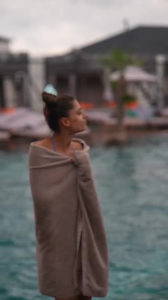 タオルと水着で 活気あふれる若い女性が雨の中プールの近くで踊ります 高品質の4K映像 — ストック動画