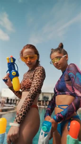 プールの近くに水砲が集まるカラフルな水着の鮮やかな少女たち 高品質の4K映像 — ストック動画
