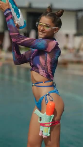 ウォーターピストルを手に プールでコスプレダンスをする美しい若い女の子 高品質の4K映像 — ストック動画