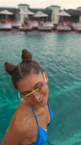 コスプレヘアスタイルのビキニの若くてアクティブな女の子がプールでジャンプしています 高品質の4K映像 — ストック動画