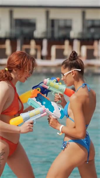 Flickor Bikini Med Vattenpistoler Står Ansikte Mot Ansikte Nära Poolen — Stockvideo