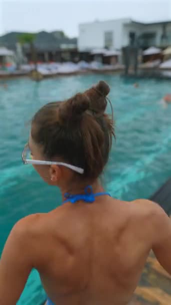 ビキニの美しい少女がプールでジャンプします 高品質の4K映像 — ストック動画
