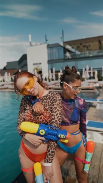 Medence Területén Élénk Lányok Szemet Gyönyörködtető Fürdőruhában Játékosan Felfegyverkezve Vízipisztollyal — Stock videók