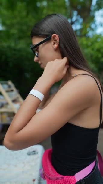 그녀의 손목에 테이프와 활기찬 소녀는 전시회에서 팔찌를 테스트하고있다 고품질 Fullhd — 비디오