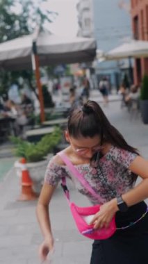 Trafiğin en yoğun olduğu saatte, güzel bir genç kadın telefonunu çantasından almak ve telefona bakmak için acele eder. Yüksek kalite 4k görüntü