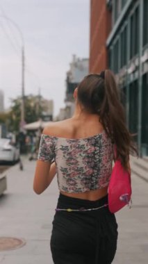 Trafiğin en yoğun olduğu saatlerde, dinamik, genç bir kadın caddede aceleyle yürürken telefonuyla konuşuyor. Yüksek kalite 4k görüntü