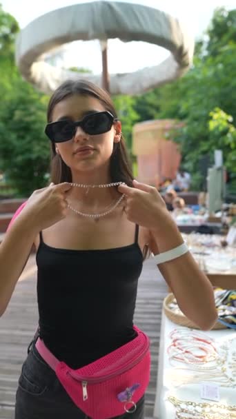 市場でイヤリングを試す若い少女の魅力的な顔 高品質のフルHd映像 — ストック動画