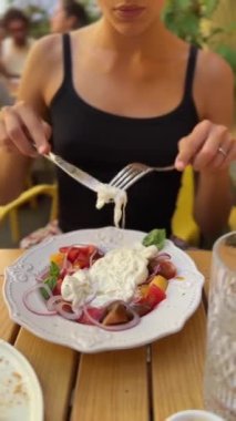 Bir kız restoranda burrata peynirinin tadını çıkarıyor. 4k görüntü