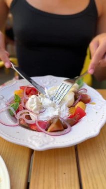 Kız restoran ortamında burrata peynirinin tadını çıkarıyor. 4k görüntü