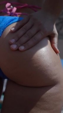 Bacakları ve kalçalarına güneş kremi sürerken kız önlem alıyor. Yüksek kalite 4k görüntü