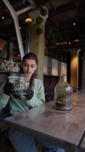 꽃집에 손톱을 소녀는 항아리에 샘플을 제시하고있다 고품질 — 비디오