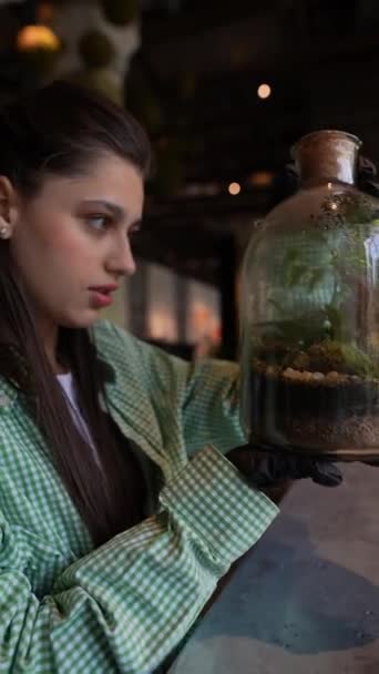 Een Bloemist Die Een Meisje Presenteert Voorbeelden Van Planten Glazen — Stockvideo