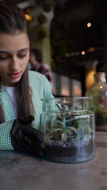 若い女性花屋は ガラス瓶にさまざまな植物サンプルを提示しています 高品質の4K映像 — ストック動画
