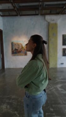 Genç kadın galeride resim yapmayı düşünüyor. Yüksek kalite 4k görüntü