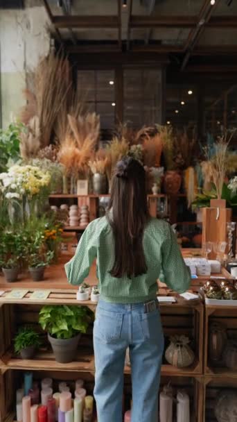 若い女の子の顧客は 花屋で製品を観察しています 高品質の4K映像 — ストック動画