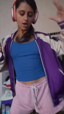 Canlı genç bir bayan şarkı söylerken saç fırçasını geçici mikrofon olarak kullanıyor. Yüksek kalite 4k görüntü