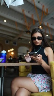 Genç ve çekici kız akıllı telefonundaki bir video oyununa aktif olarak dahil oldu. Yüksek kalite 4k görüntü