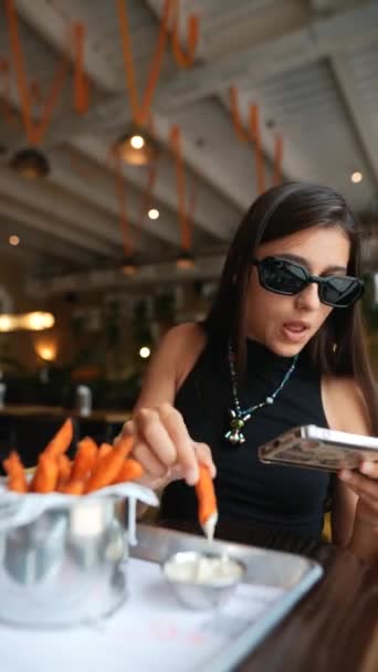 Restaurante Una Chica Joven Hermosa Absorbe Activamente Videojuego Teléfono Inteligente — Vídeo de stock