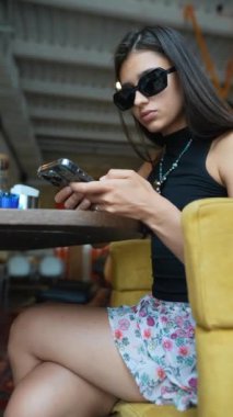 Kız, genç ve güzel, akıllı telefonuyla bir video oyununa dalmış durumda. Yüksek kalite 4k görüntü