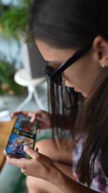 Mobil cihazında video oyununa takılmış güzel bir genç kadın. Yüksek kalite 4k görüntü