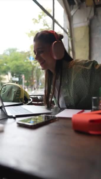 Ett Kafé Konverserar Ung Flicka Med Hörlurar Sin Laptop Högkvalitativ — Stockvideo