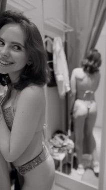 Mağazada, genç bir kız bedenine göre bikini deniyor. Yüksek kalite 4k görüntü