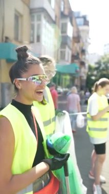 Gönüllü olarak, bir kız şehrin sokaklarından çöp topluyor ve onları özel çöp torbalarına koyuyor. Yüksek kalite 4k görüntü