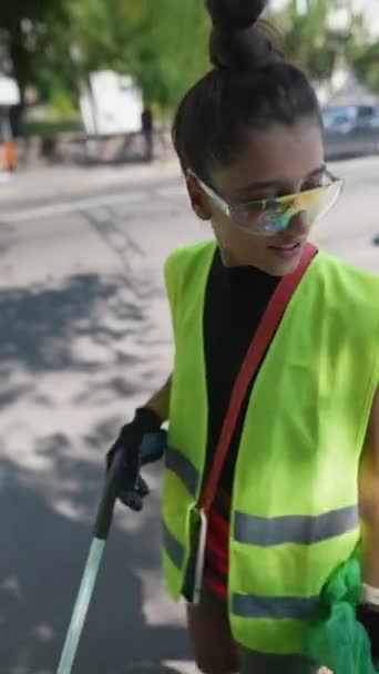 ボランティア活動に従事する若い女性は 都市の通りからゴミを取り出し 専門の廃棄物袋に入れています 高品質の4K映像 — ストック動画