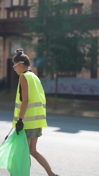 作为一名志愿者 一名女孩正在城市街道上收集垃圾 并将其放入指定的垃圾袋中 高质量的4K镜头 — 图库视频影像