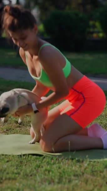 一只哈巴狗和一个年轻的女运动员正在公园参加早上的训练 高质量的4K镜头 — 图库视频影像