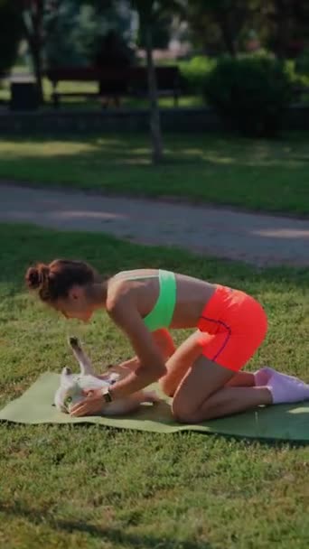 彼女の朝の運動のルーチンの中で 若いアクティブな女の子は公園で彼女のパグ犬と遊ぶ時間を費やしています 高品質の4K映像 — ストック動画