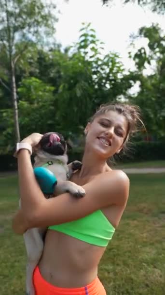 Eine Junge Frau Sportkleidung Spielt Fröhlich Mit Ihrem Mops Auf — Stockvideo