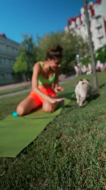 Αθλητική Στολή Της Μια Νεαρή Γυναίκα Χαρούμενα Παίζει Σκυλί Pug — Αρχείο Βίντεο