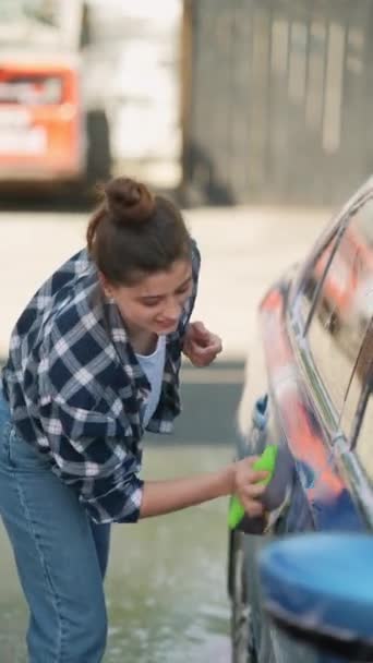 Myjnią Jako Tłem Dziewczyna Oddaniem Myje Swój Samochód Pomocą Gąbki — Wideo stockowe