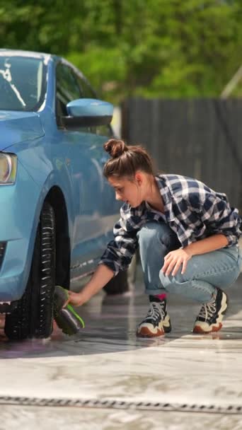 Wśród Ustawień Myjni Samochodowej Piękna Dziewczyna Szoruje Koła Samochodowe Wysokiej — Wideo stockowe
